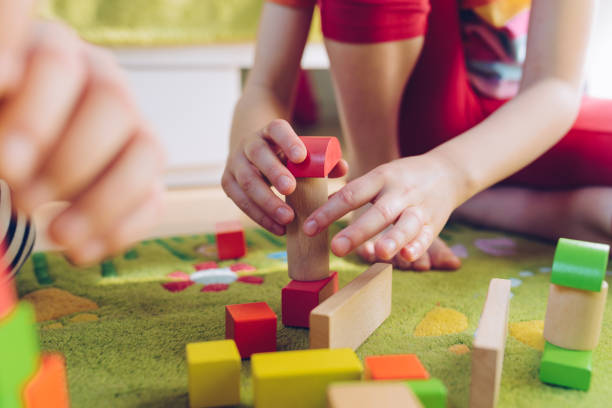 istock Small child playing with wooden blocks on green carpet 1088389352