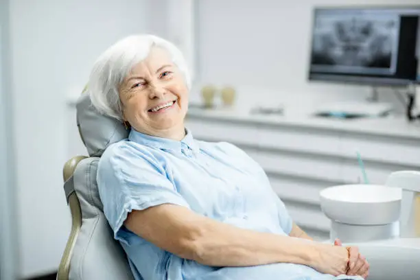 Portrait of a beautiful senior woman with healthy smile sitting at the dental office