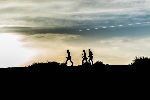 istock people walking in nature in sunset - symbol 1088392798