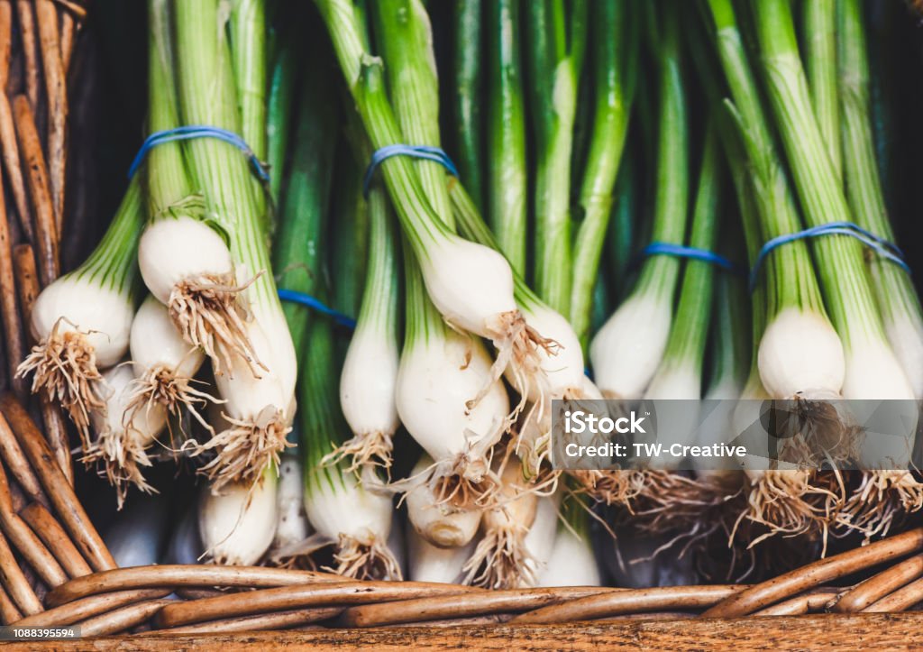 Onions Spring onions in a basket freshly picked at a farm market shop. Fresh veg vegetables Scallion Stock Photo