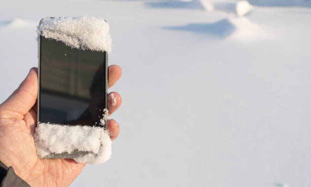 istock Phone in mens hand in winter snowy forest 1088406156
