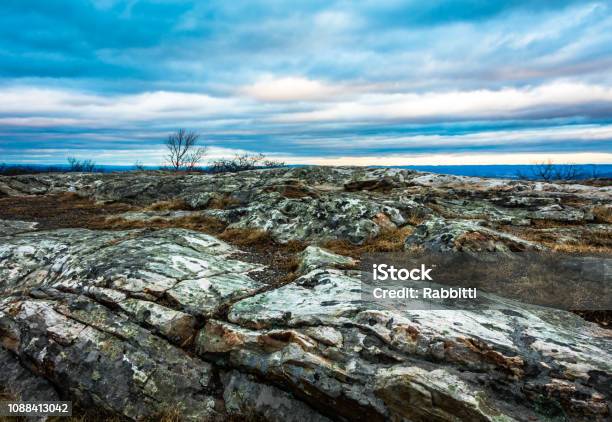 Rocky Granite Outcroppings Under A Beautiful Blue Cloudy Sky At Dusk High Point Monument At The Top Of Nj In Winter Stock Photo - Download Image Now