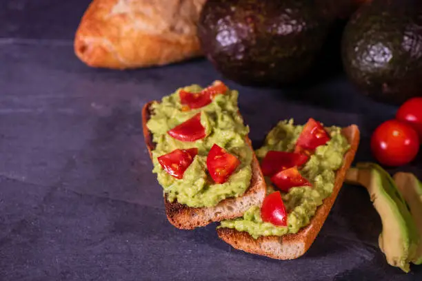 Avocado toast and its ingredients: baguette, avocados, and tomatoes