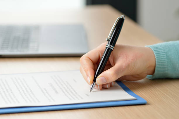 signing the new contract Cropped shot of a businesswoman hand signing a contract on a desk at office witness signature stock pictures, royalty-free photos & images