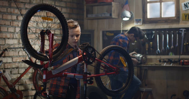istock Father and son repairing a bicycle in a garage 1088423056