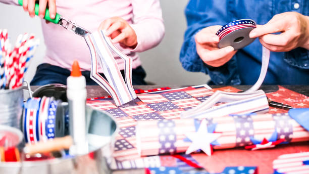 istock Mother and daughter making paper firecrackers for July 4th celebration. 1088434320