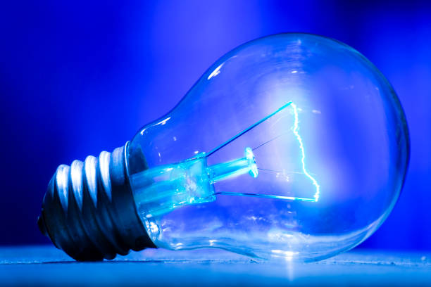Electric bulb lamp with a spiral on a blue background.
