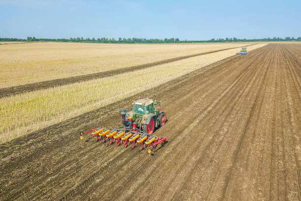 istock Farmer seeding crops at field. Seeding Aerial View. 1088448516