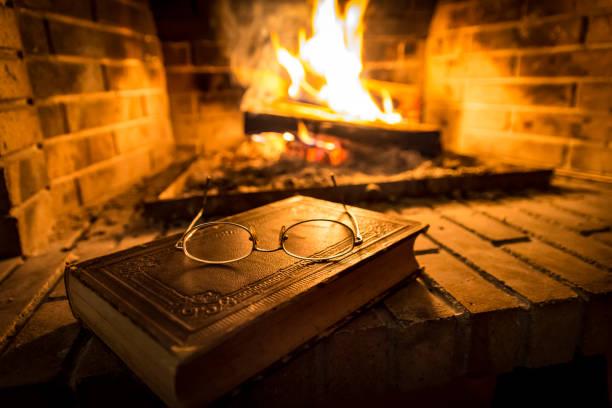 Old  book beside fireplace stock photo