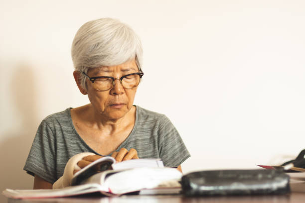 istock Senior woman reading a book at home 1088453278