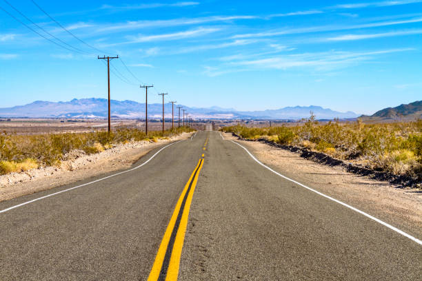 strada solitaria della route 66 nel deserto del mojave, california - arid climate asphalt barren blue foto e immagini stock