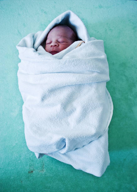 New-born baby wrapped in blanket stock photo