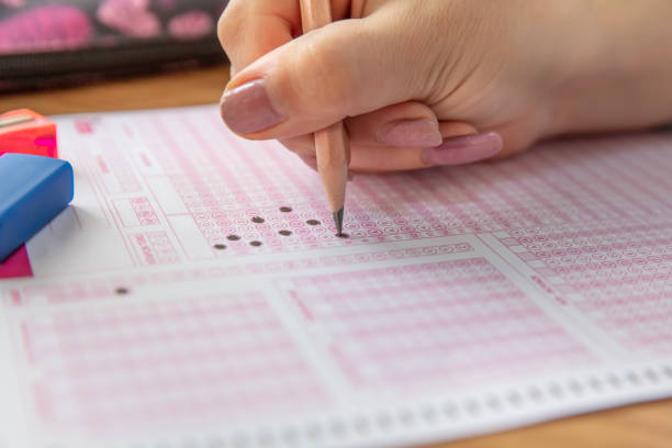 istock hand student testing in exercise and taking fill in exam carbon paper computer sheet with pencil at school test room, education concept 1088503158