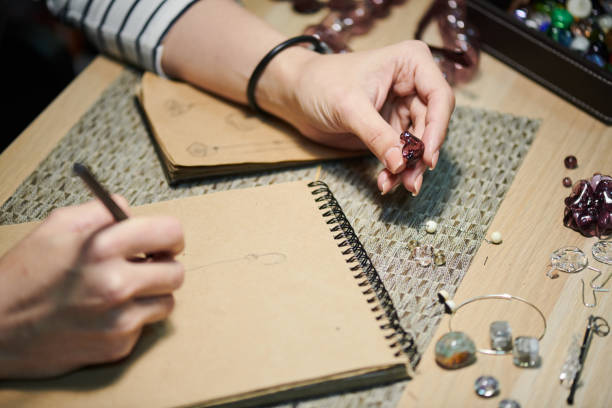 Woman Creating Jewelry Closeup of unrecognizable woman drawing sketches while creating beautiful handmade jewelry, copy space jewelry craftsperson craft jeweller stock pictures, royalty-free photos & images