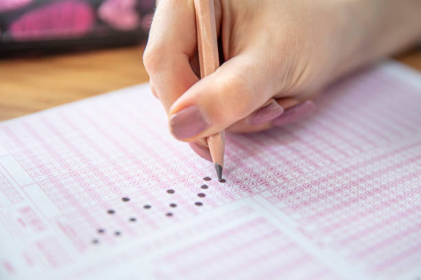 istock hand student testing in exercise and taking fill in exam carbon paper computer sheet with pencil at school test room, education concept 1088505962