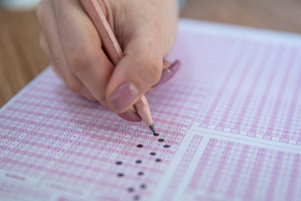 istock hand student testing in exercise and taking fill in exam carbon paper computer sheet with pencil at school test room, education concept 1088509610