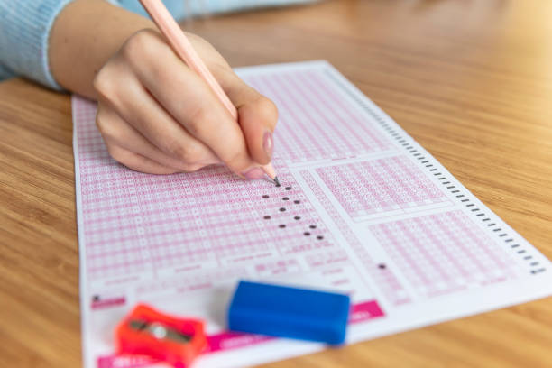 istock hand student testing in exercise and taking fill in exam carbon paper computer sheet with pencil at school test room, education concept 1088510842