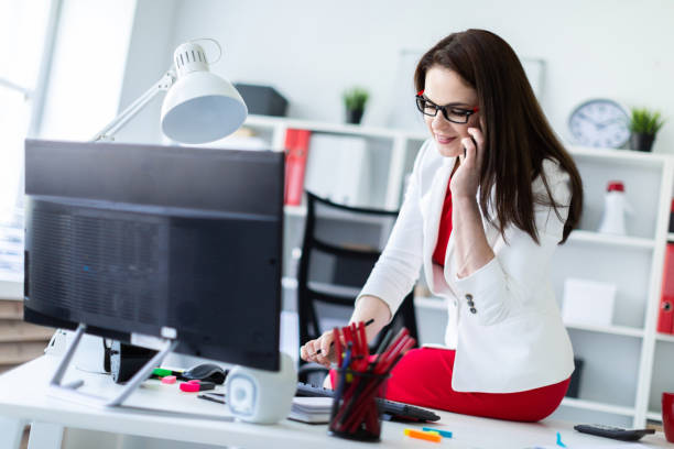 istock A young girl sat down on a Desk in the office and works with documents and a computer. 1088536522