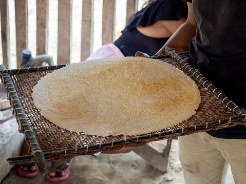 Baking a yuka-based bread on a plate made of fireclay. It is a traditional Siona food. Picture taken in one of Siona indigenous villages in Cuyabeno Wildlife Reserve, Ecuador.