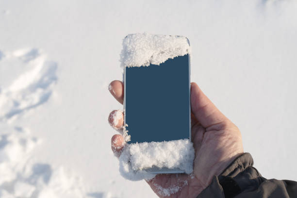 istock Phone in mens hand in winter snowy forest 1088589982