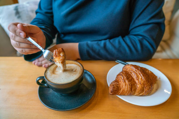 istock Girl eating croissant and drinking coffee 1088596818