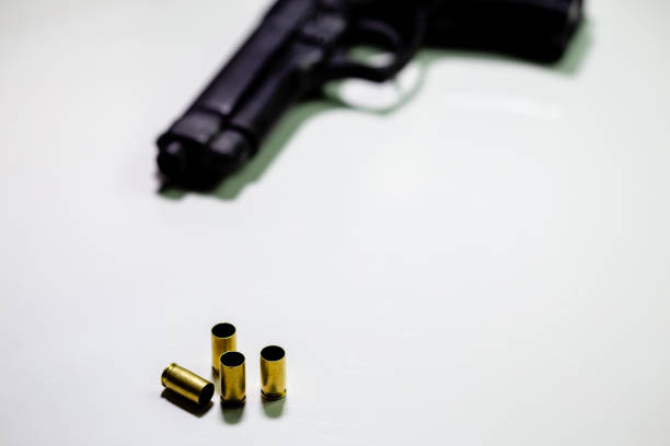 istock Handgun with 9mm shell casings on white table 1088620126