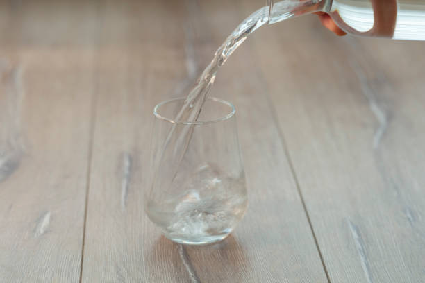 istock Soda or Water being poured into plain glass with ice 1088633592