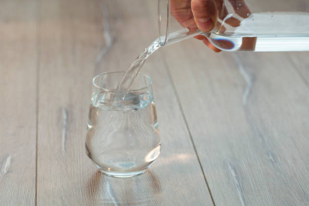 istock Soda or Water being poured into plain glass with ice 1088634012