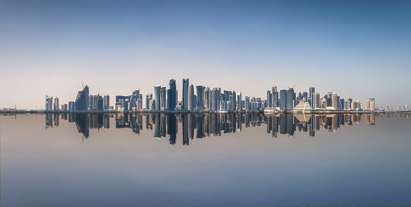 The iconic skyline of Doha, Qatar, with the modern skyscrapers with reflections on the sea