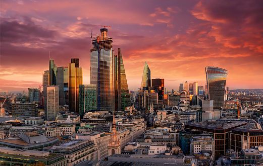 Fiery sunset over the urban skyline of the financial district City of London, United Kingdom