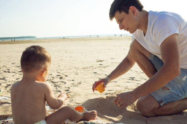 istock Young father playing with his son in the sand on the beach. 1088641962