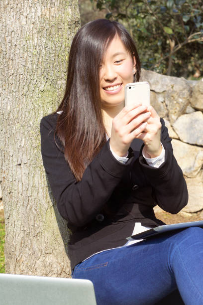 istock Asian business woman in park working with pc 1088646796