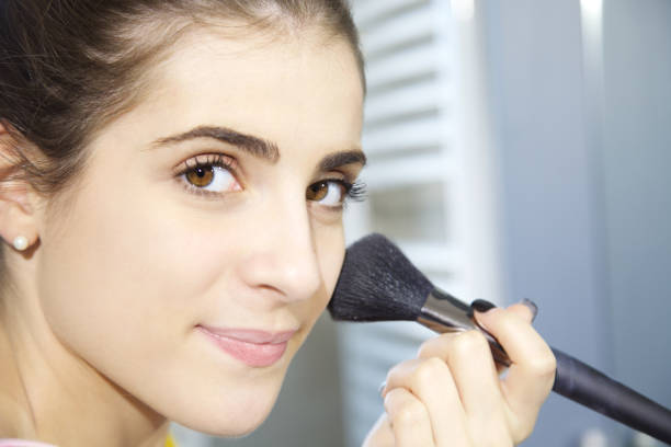 istock cute woman putting makeup looking camera 1088647258