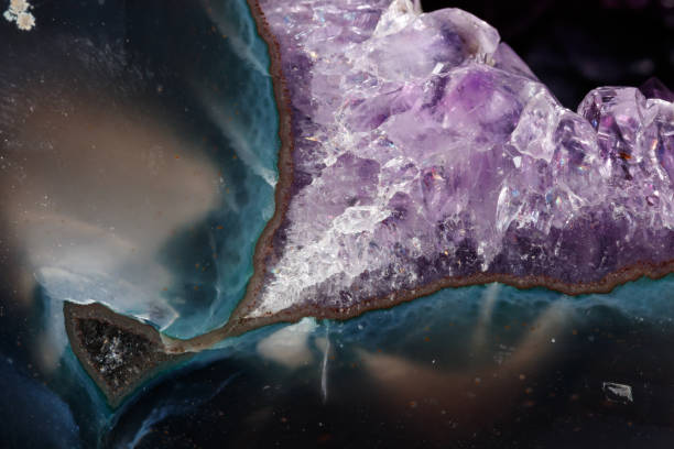 istock Macro Mineral Stone Amethysts in the rock on a white background 1088665848