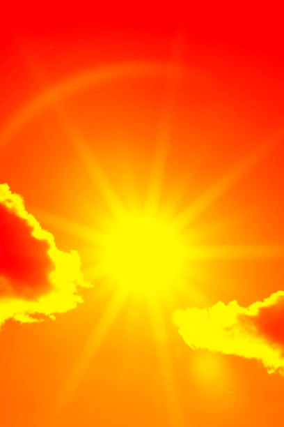 Bright sun with beautiful beams in the sky with clouds. Toned in orange color, space for copy.