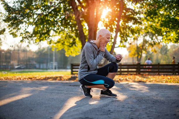 Keep track of your heart rate during your exercise Senior Athletic Woman Checking Heart Rate After Running in the Park. Portrait of Mature Woman Check Her Pulse on Neck while Taking Break From Jogging taking pulse stock pictures, royalty-free photos & images
