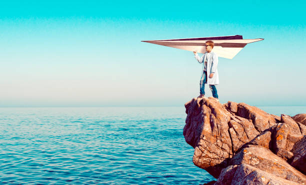 вундеркинд создал большую бумажную плоскость и готов позволить ей взлетать - aspirations pilot child airplane стоковые фото и изображения