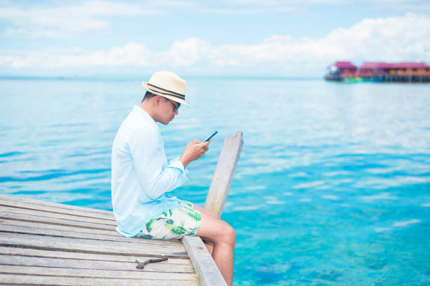 istock a handsome man sit and enjoy on the derawan island, borneo, Indonesia 1088701420