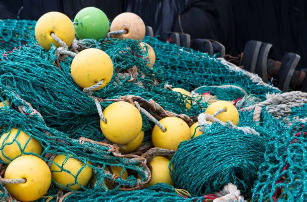 Image shows background of colorful fishing nets and floats