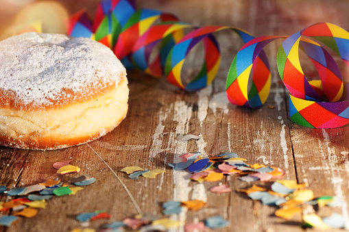 Donut with colorful carnival decoration on rustic wooden table