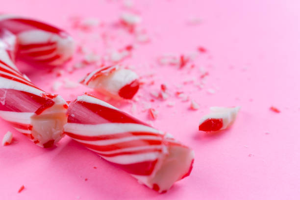сломанной конфеты на розовом фоне. крупным планом фото - stick of hard candy candy striped toughness стоковые фото и изображения