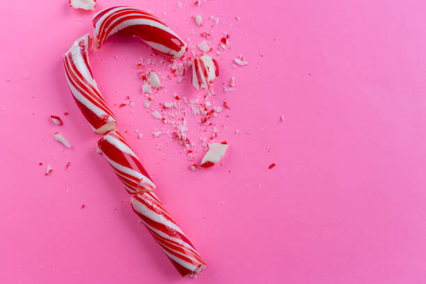 istock broken candy cane on pink background. close-up photo 1088729234