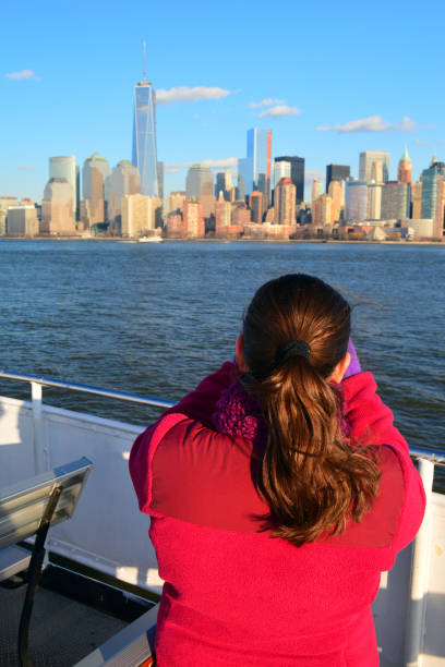 Om the New York Ferry A young girl takes in the view of lower Manhattan from a ferry ferry deck girls stock pictures, royalty-free photos & images
