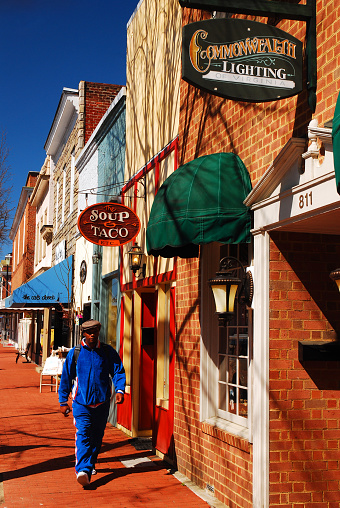 Fredericksburg, VA, USA March 29, 2012 An adult man walks by small cafes and boutique stores in charming downtown Fredericksburg, Virginia