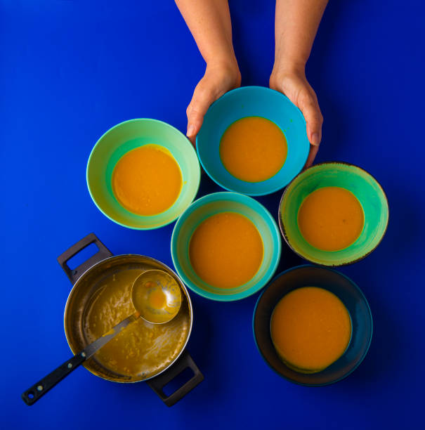 istock holding a bowl of pumpkin soup top view 1088732900