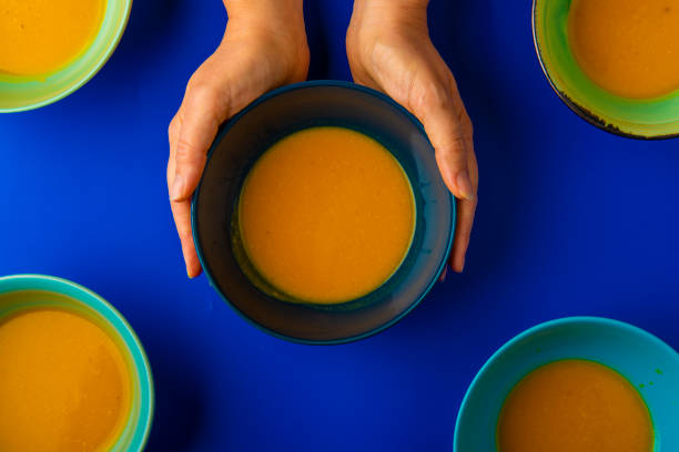 istock holding a bowl of pumpkin soup top view 1088734236