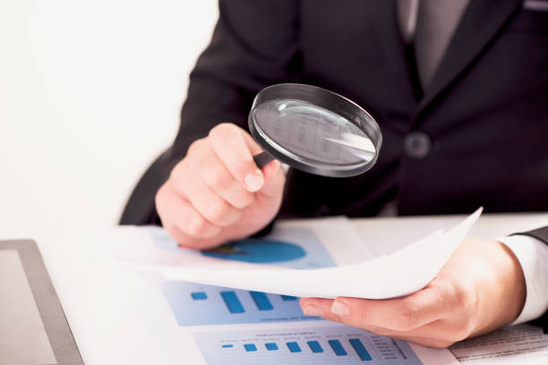 istock Male hand with magnifier investigating some documents 1088740742