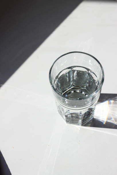 istock Water glass. Glass with strong shadows on white background 1088747730