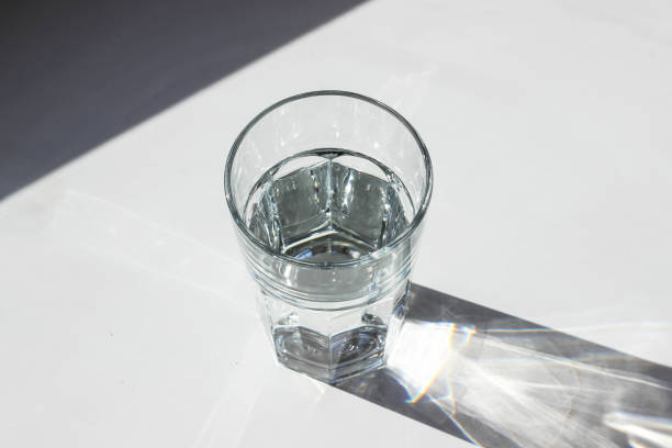 istock Water glass. Glass with strong shadows on white background 1088747736