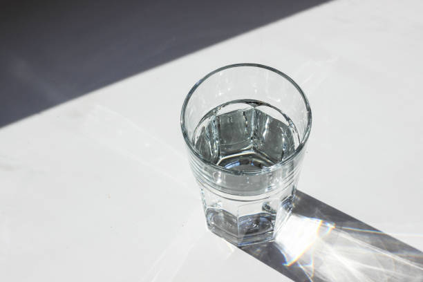 istock Water glass. Glass with strong shadows on white background 1088747744